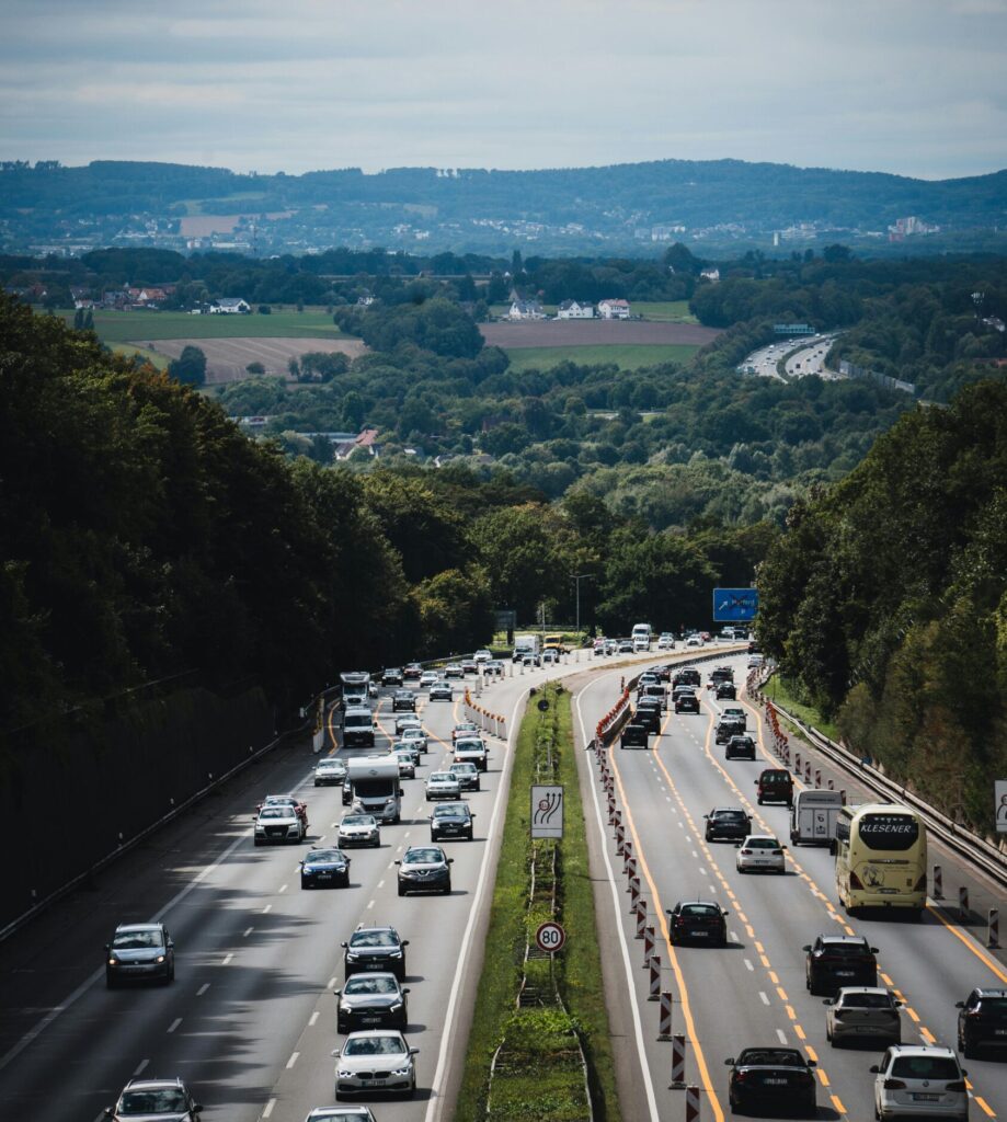 A scenic view of a busy highway in Herford, Germany, surrounded by lush greenery and hills.